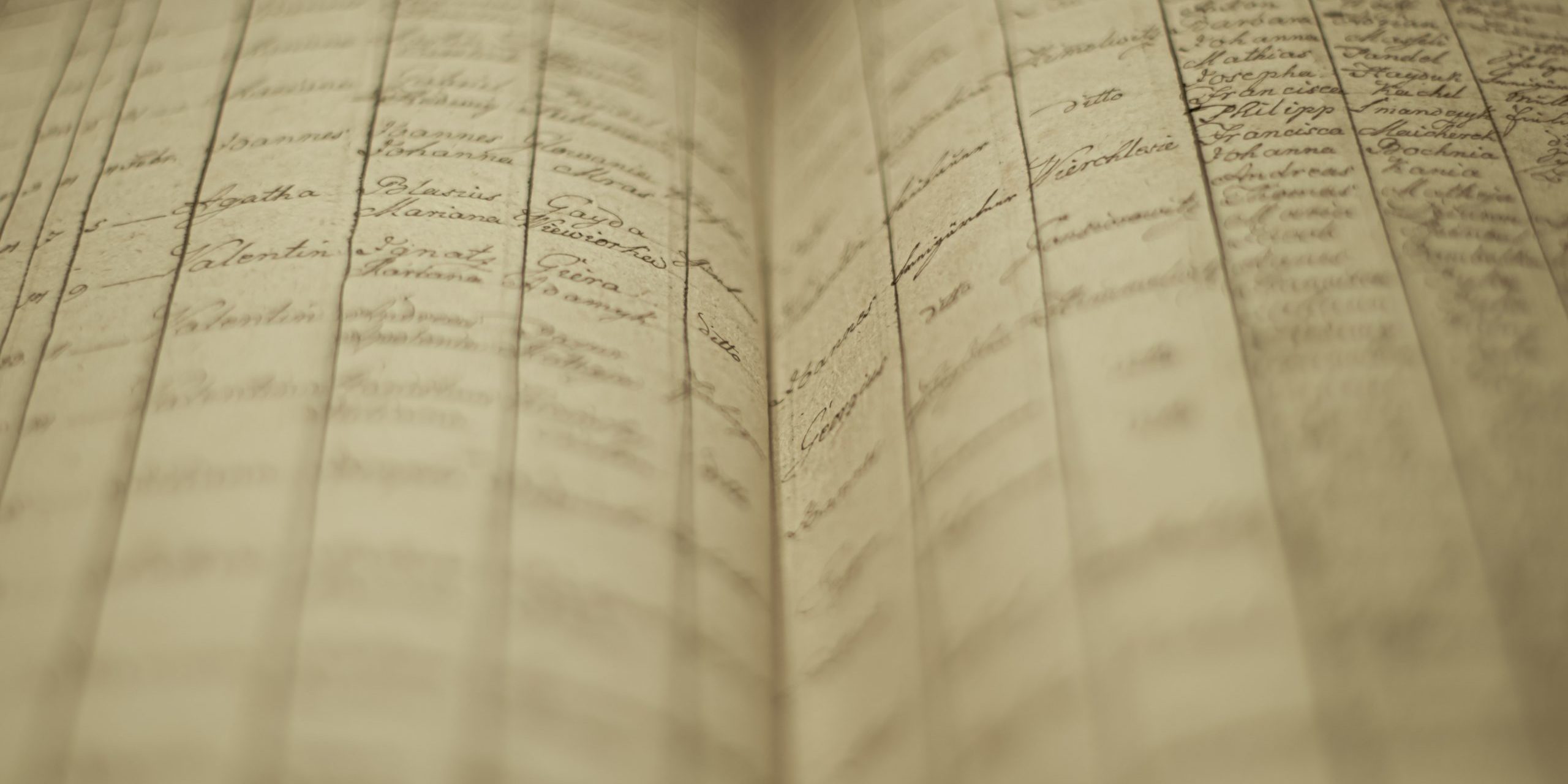 Soft focus of an old book of local records with list of residents’ names and information