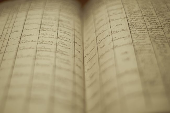Soft focus of an old book of local records with list of residents’ names and information